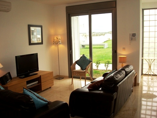 Living room with flat panel TV and access to communal gardens